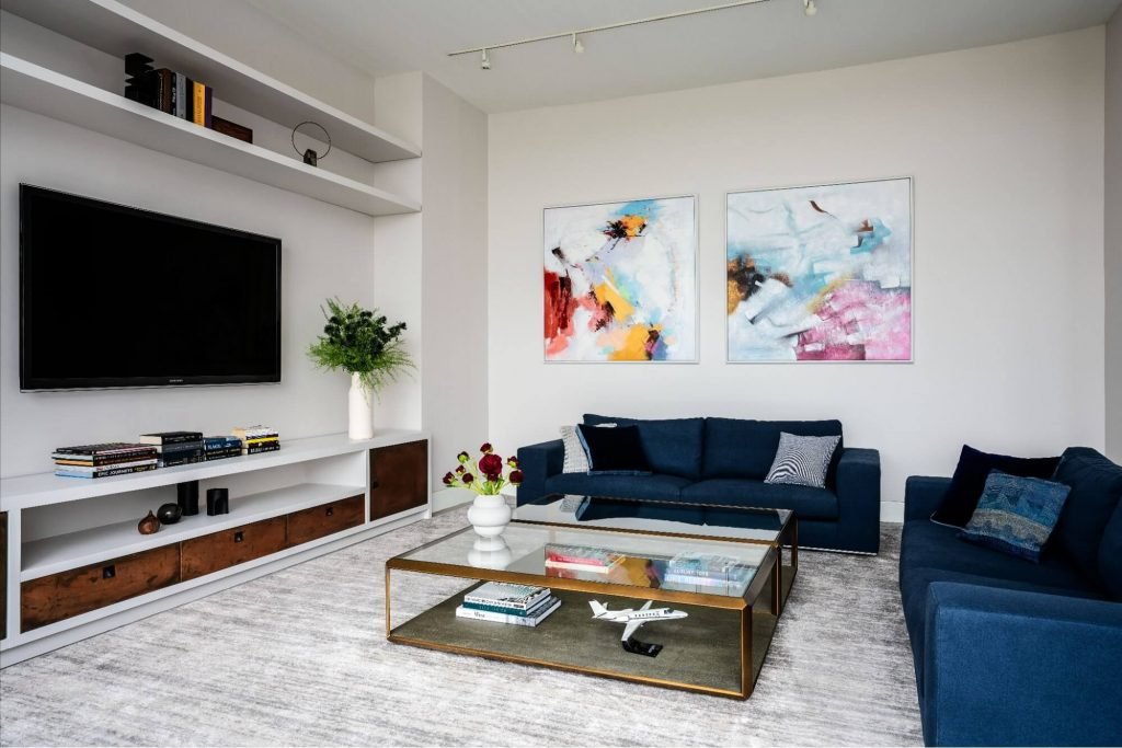 two blue sofas and a tv in a living room